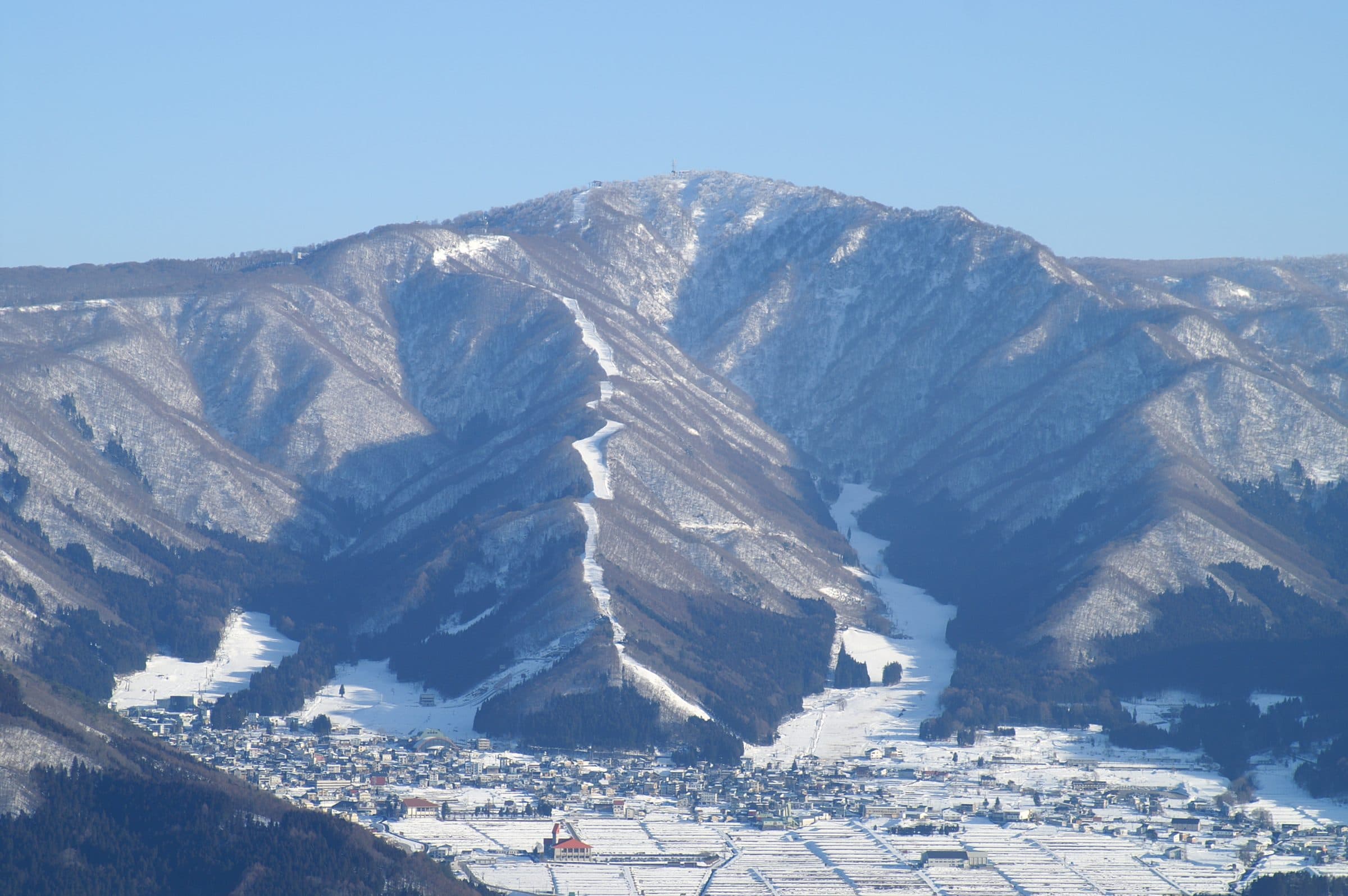 Mount Kenashi ski runs above Nozawa Onsen village in winter